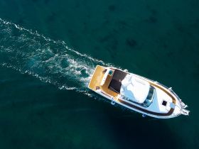 Aerial view of a sleek boat cruising through clear waters, showcasing its elegant design and perfect for a day on the water.