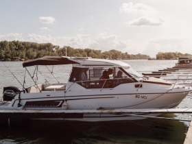 A side view of a sleek yacht docked at the marina, showcasing its elegant design and spacious layout, perfect for leisurely outings on the water.
