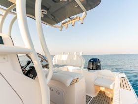 A clean and modern helm area of a boat featuring comfortable seating and a sleek console, perfect for fishing trips or leisurely cruises.