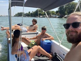 A group of friends relaxes on a boat, enjoying a sunny day on the water — perfect for summer outings and social gatherings.