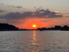 A breathtaking sunset over tranquil waters, showcasing the beauty of nature and perfect for evening boat cruises.