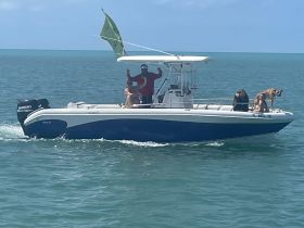 A lively group enjoys a day on the water aboard a boat, accompanied by their dogs, showcasing a fun and adventurous outing.