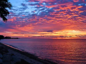 A breathtaking sunset paints the sky in vibrant hues over the tranquil waters, offering a picturesque view of the coastline — perfect for romantic evenings or serene escapes.
