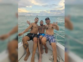 A group of friends enjoys a fun moment on a boat, celebrating together against a beautiful ocean backdrop — perfect for memorable outings and adventures.