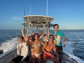 A lively group of friends enjoys a fun day on the water, celebrating together aboard a boat under the sunny sky.