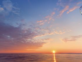 A breathtaking sunset over the ocean, showcasing vibrant colors and serene waters — perfect for capturing the beauty of nature during a boating adventure.