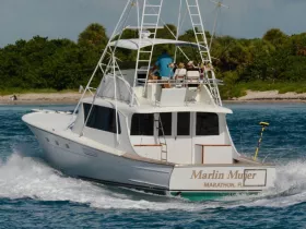 The 'Marlin Mujer' yacht cruises through the waters, showcasing its sleek design and fishing capabilities — perfect for adventure seekers in Marathon, Florida.