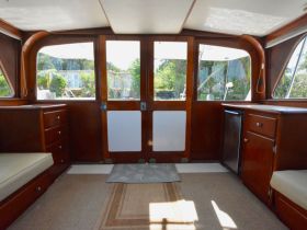 Interior view of a cozy boat cabin featuring comfortable seating and storage, perfect for relaxing while on the water.