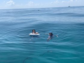 Two children enjoy a refreshing swim in crystal-clear waters, showcasing the fun of a family day on the water.