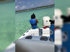 A child prepares to snorkel in the clear turquoise waters, showcasing a fun and adventurous day on the water.