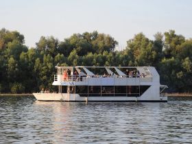 The Sirena boat is filled with guests enjoying a scenic cruise, showcasing a lively atmosphere perfect for group celebrations on the water.