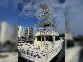 A stunning view of the 'Marlin My Darlin' yacht docked in Fort Lauderdale, showcasing its impressive structure and design against a clear blue sky.