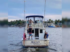 A lively group poses on the deck of the 'Bounty' boat, showcasing a fun day on the water with friends. Perfect for celebrating special occasions or enjoying a day out at sea.