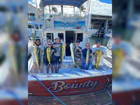 A group of anglers proudly displays their catch aboard the Bounty in Fort Lauderdale, showcasing a successful fishing trip filled with camaraderie and excitement.