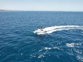 Aerial view of a sleek speedboat cruising through deep blue waters, showcasing the thrill of boating adventures on the open sea.