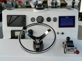 A close-up view of a boat's helm featuring modern navigation equipment and controls, perfect for those interested in boating technology and interior design.