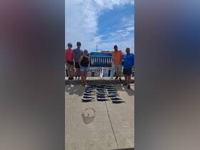 A group of friends proudly displays their fishing catch at the dock, celebrating a successful day on the water. Perfect for fishing enthusiasts and adventure seekers.