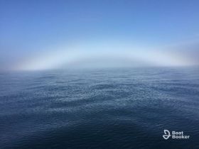 A hazy view of the ocean with a faint arc in the distance, creating an unclear and atmospheric scene.