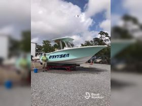 A vibrant yacht named 'Odysea' is showcased on a trailer, highlighting its sleek design and ready-for-adventure appeal.