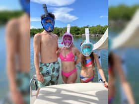A family enjoys a fun snorkeling adventure, equipped with full-face masks, ready to explore the underwater world in clear waters.