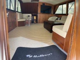 Interior view of a well-appointed boat cabin featuring comfortable seating and a cozy atmosphere, perfect for relaxation while cruising.