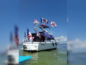 A decorated boat proudly displays various flags while docked in calm waters, showcasing a festive atmosphere perfect for gatherings on the water.