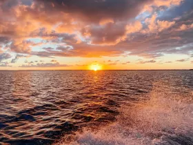 A breathtaking sunset over the ocean, with vibrant colors reflecting on the water — a perfect backdrop for evening cruises and serene moments on the water.