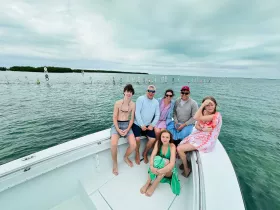 A cheerful group of family and friends enjoys a day on the water, capturing the essence of fun and togetherness aboard their boat.