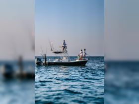 A group of friends enjoys a fishing trip on a boat, showcasing the fun and camaraderie of a day on the water.
