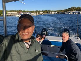 A cheerful group enjoys a day on the water, capturing a fun moment aboard their fishing boat. Perfect for creating lasting memories on a fishing adventure.