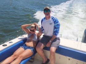 A couple enjoys a sunny day on the boat, capturing the essence of relaxation and fun on the water.