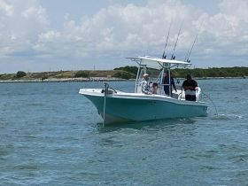 A group of friends enjoys a fishing trip aboard a boat, showcasing the excitement of on-water activities and camaraderie.