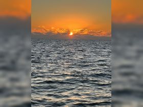 A breathtaking sunset over the ocean, casting vibrant colors across the sky and water — a perfect backdrop for evening boat trips.