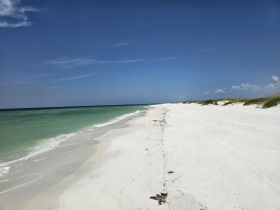 A stunning view of a pristine beach with white sand and turquoise waters, perfect for relaxing and enjoying the natural beauty of the coastline.