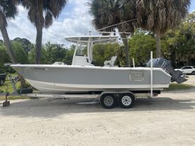 A sleek center console boat docked and ready for adventure, showcasing its modern design and features amidst a scenic backdrop.