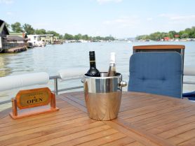 A stylish setup featuring a cooler with wine bottles and a sign indicating the Captain's Bar is open, perfect for enjoying refreshments on the water.