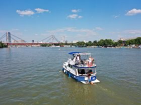 A lively scene featuring a boat cruising through the city waters, with people enjoying the summer sun — a perfect backdrop for urban adventures on the water.