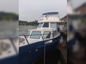 A clear view of the 'TEXY' boat docked by the water, showcasing its sleek design and structure, perfect for leisurely outings.