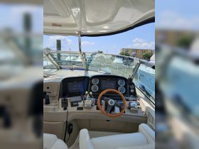 An interior view of a boat's helm showcasing advanced navigation equipment and a comfortable seating area, perfect for steering adventures on the water.