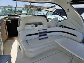 A spacious and stylish interior view of a boat's cabin, featuring comfortable seating and a well-equipped helm, perfect for relaxing or navigating on the water.