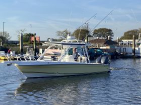 A sleek speedboat named 'Salt Shaker' navigates through calm waters, showcasing its stylish design and fishing gear — perfect for a day on the water.