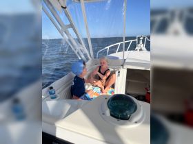 Two children enjoy a moment inside the cabin of a boat, showcasing a cozy and inviting space for family outings on the water.