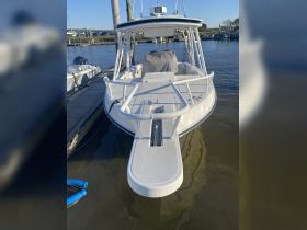A clear view of a center console boat docked at the marina, showcasing its sleek design and structure, perfect for fishing or leisure outings.