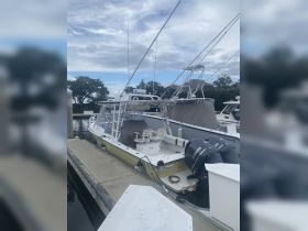 A side view of a center console boat docked at the marina, showcasing its sleek design and fishing capabilities.