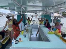 A lively group of friends enjoys a fun day on the water, celebrating together aboard a boat with drinks and laughter.