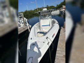A sleek speedboat docked at the marina, showcasing its design and structure against a serene water backdrop.