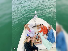 A group of friends enjoys a delightful meal on a boat, capturing the essence of a fun day on the water with good food and great company.