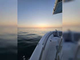 A serene view of a boat's bow cutting through calm waters at sunset, showcasing the tranquil beauty of evening cruises.