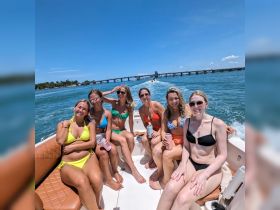 A lively group of friends enjoys a sunny day on the water, showcasing the perfect summer boating experience with laughter and camaraderie.