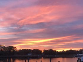 A stunning sunset paints the sky with vibrant hues, reflecting beautifully on the water — a picturesque moment perfect for evening boat outings.